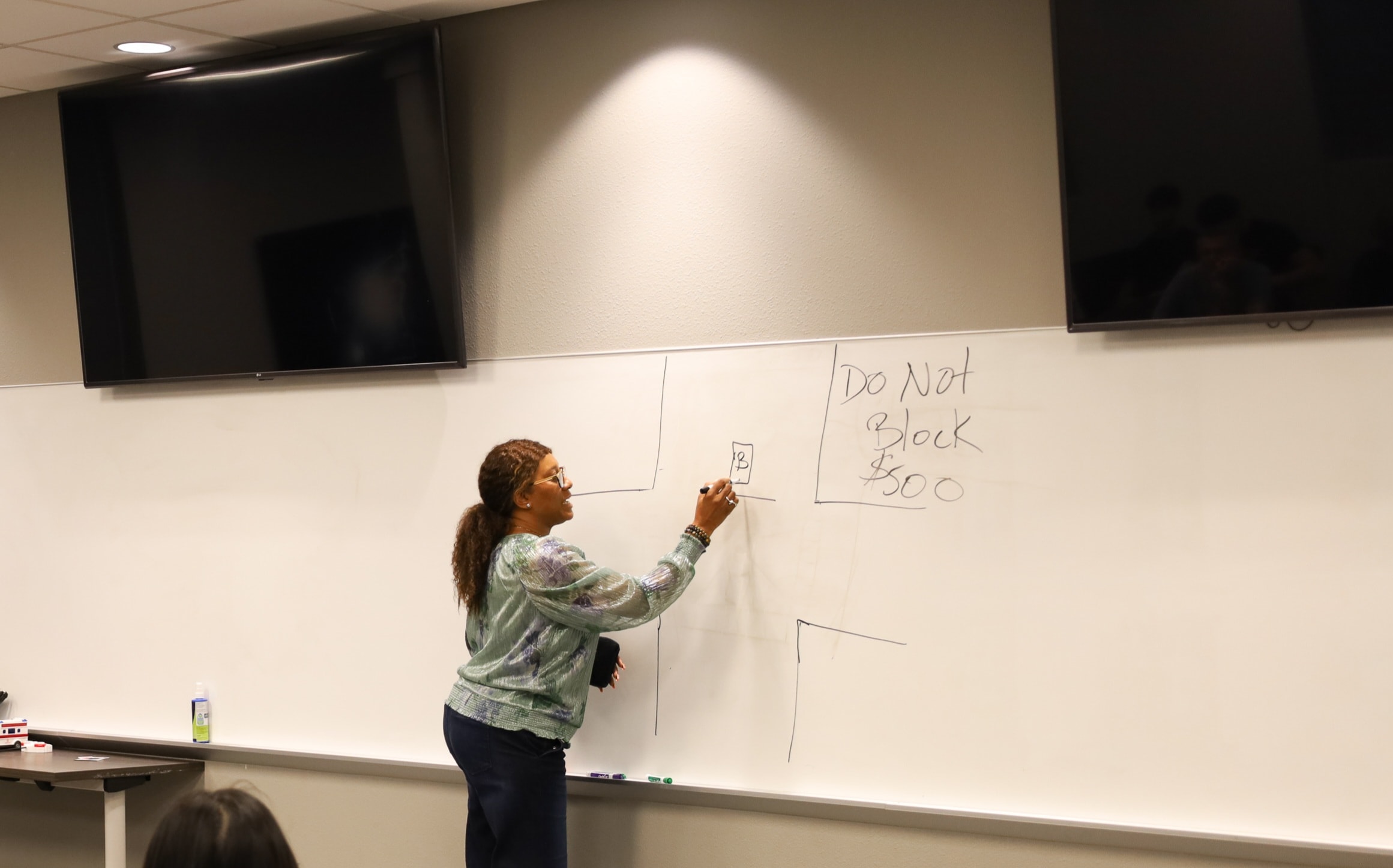 LaDonna Claude teaching at whiteboard during safe driving class